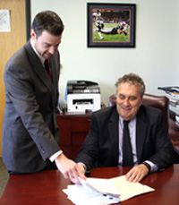 Jeff Weeden, left, and Executive Director Charles J. Gaeta go over paperwork at the Lynn Housing Authority & Neighborhood Development office prior to receiving a grant award for $250,000 that they picked up in Boston on Wednesday.