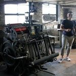 Chirag Savaliya, the developer who  purchased the former Lynn Item building, 38 Exchange St. standing inside the building next to an old printing press.