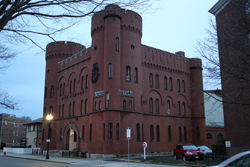 Facade of old armory building that is a romanesque-style brick building