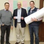 rocopio Enterprises Inc. presents a check for $850,000 to the city to pay for their building permits for their development on Munroe Street. From left, Kevin Procopio, James Cowdell and Michael Procopio.