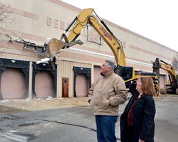 Building owner Charlie Patsios and Mayor Judith Kennedy watch as the demolition of the Old GE building on Federal Street in Lynn begins.